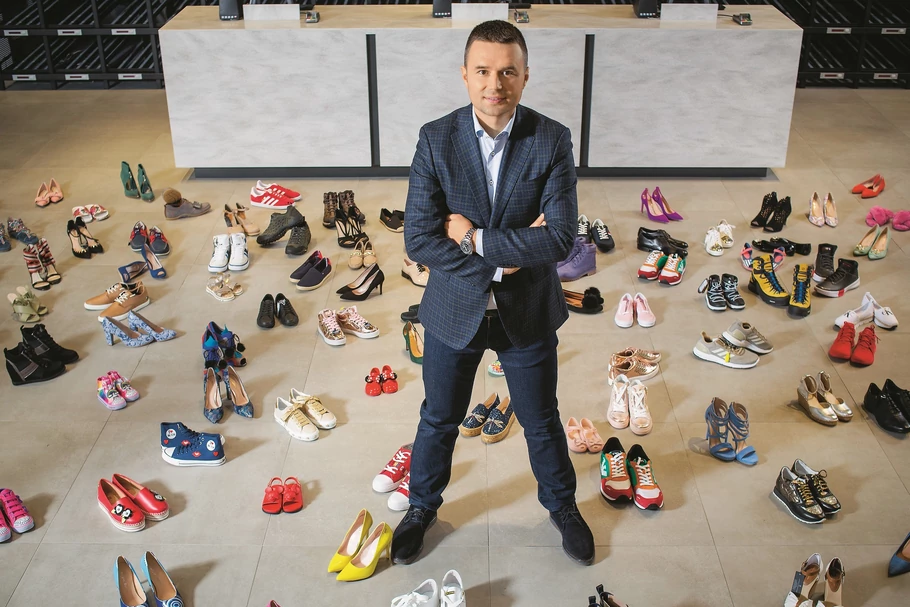 Marcin Grzymkowski. Można o nim powiedzieć: „w butach urodzony”, bo temu, jak sprzedaje się buty, przyglądał się od małego, towarzysząc rodzicom w ich sklepie stacjonarnym. A kiedy dorósł, na zapleczu tego sklepu zbudował eobuwie, absolutny fenomen polskiego e-commerce. Pod okiem Grzymkowskiego sklep przez 16 lat, rok w rok, rósł o 100 proc., nieustająco wykazując rentowność. Dziś przedsiębiorca gotowy jest na nowe biznesowe wyzwania. I już działa, bo nie lubi bezczynności.